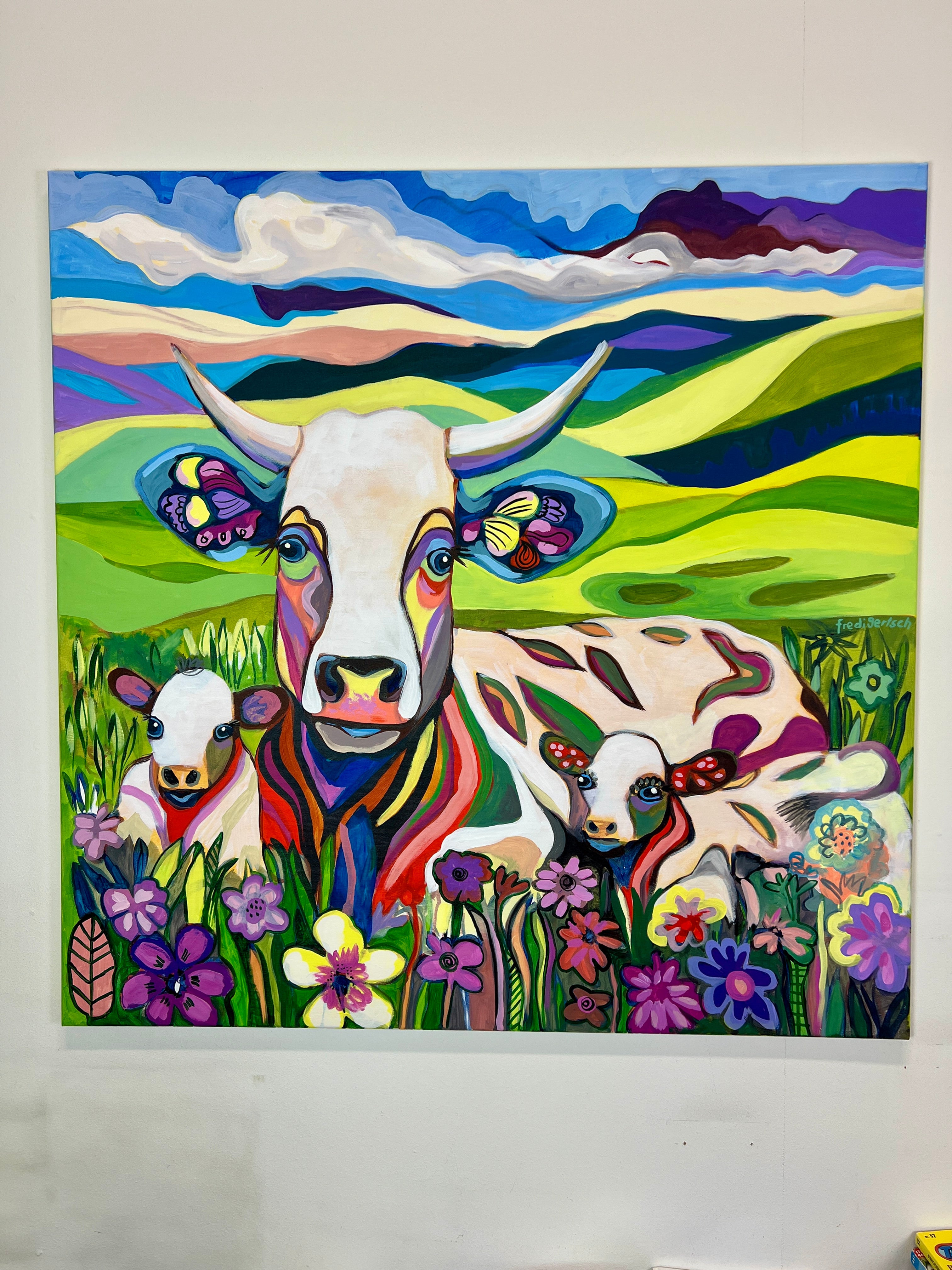 Pop Art Kuh 100x100cm BabyMum Blumenwiese, Kuh zwei Kälbchen Hügellandschaft Wolken, Familie Geborgenheit, Acryl Leinwand Original Fredi Gertsch, an weisser Wand