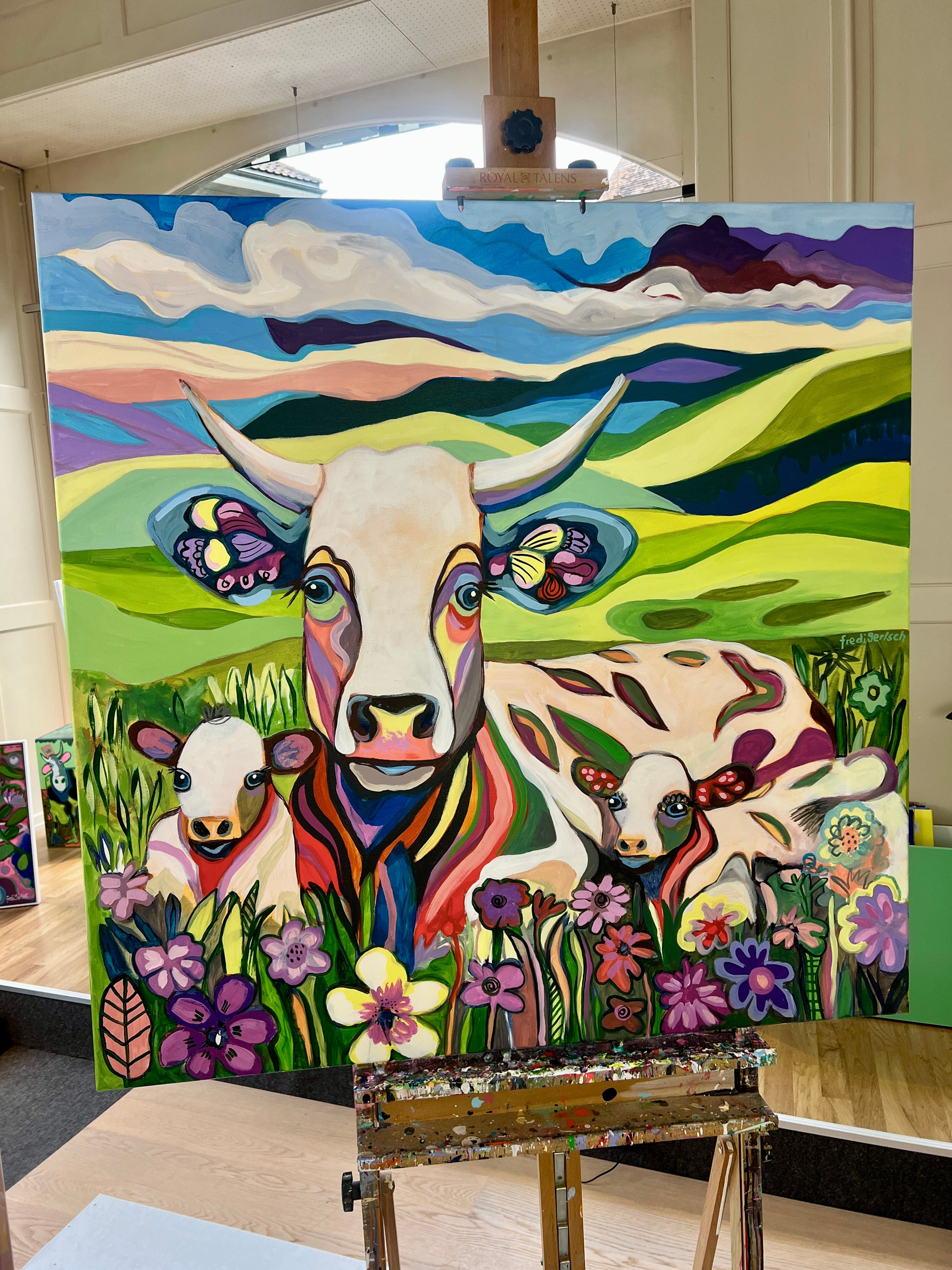 Pop Art Kuh 100x100cm BabyMum Blumenwiese, Kuh zwei Kälbchen Hügellandschaft Wolken, Familie Geborgenheit, Acryl Leinwand Original Fredi Gertsch, auf Staffelei